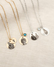 Set of necklaces with personalized pendants on a neutral background