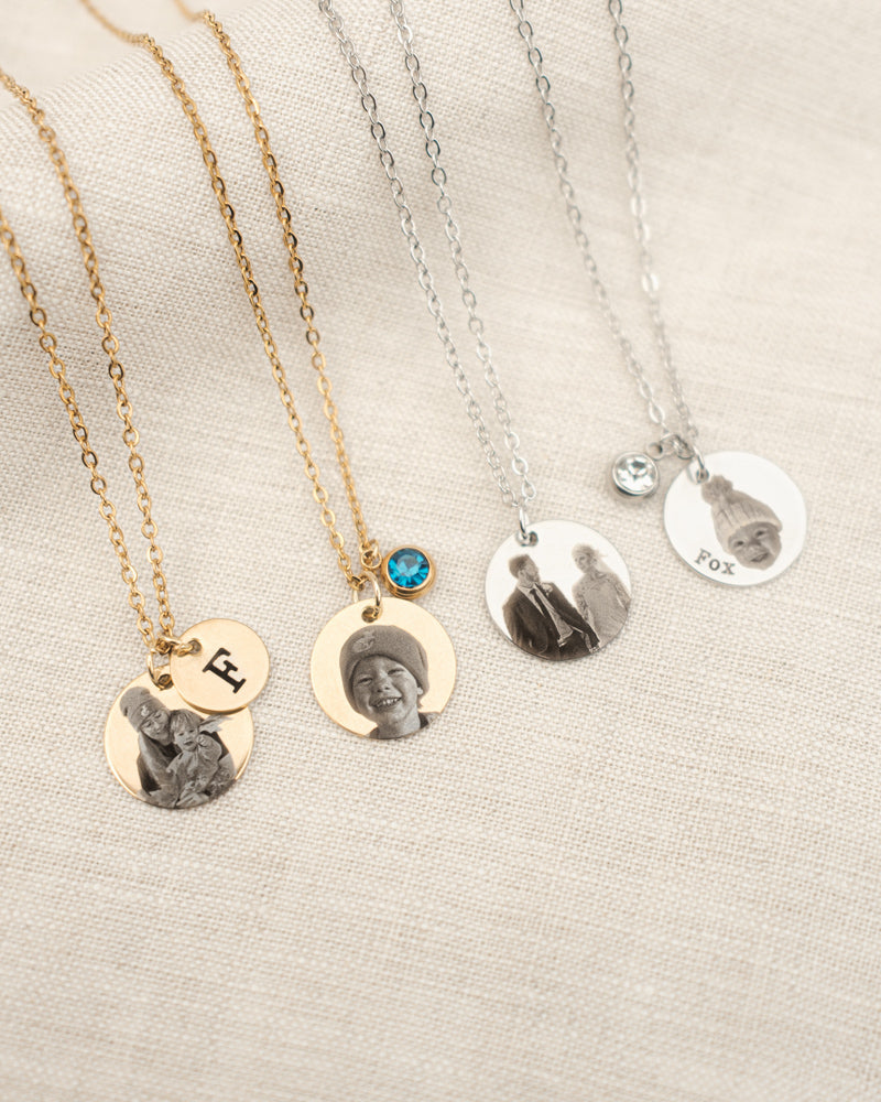 Set of necklaces with personalized pendants on a neutral background